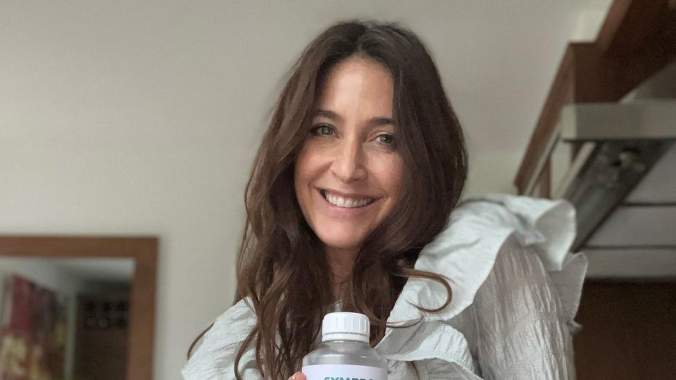 Lisa Snowdon holding a bottle of  Symprove