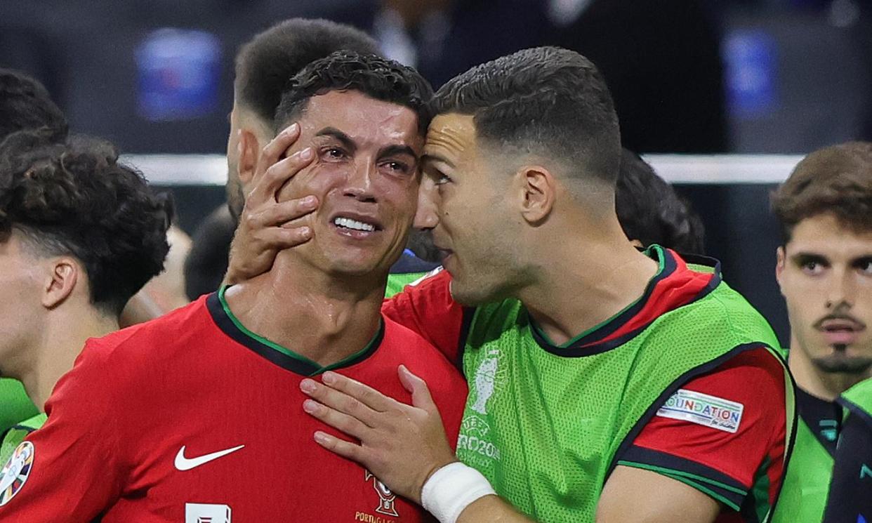 <span>Tearful Cristiano Ronaldo is comforted by teammate Diogo Dalot during the break before extra time against Slovenia at the Frankfurt Arena.</span><span>Photograph: Ralf Ibing/firo sportphoto/Getty Images</span>