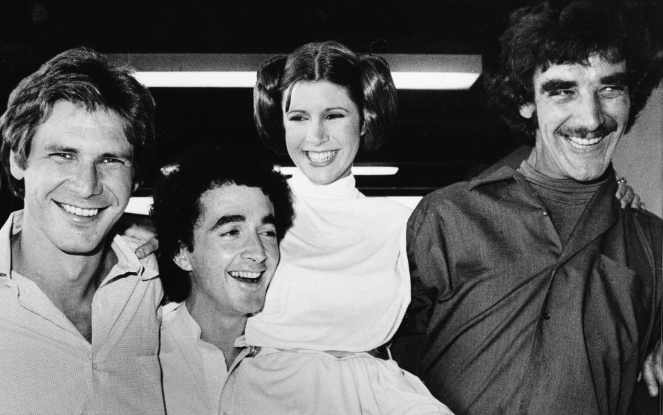 ADDS NAME OF CARRIE FISHER'S CHARACTER AND BYLINE - FILE - In this Oct. 5, 1978, file photo, actors featured in the "Star Wars" movie, from left, Harrison Ford who played Han Solo, Anthony Daniels who played the robot C3P0, Carrie Fisher who played Princess Leia, and Peter Mayhew who played the Wookie, Chewbacca, are shown during a break from the filming of a television special presentation in Los Angeles. Mayhew, who played the rugged, beloved and furry Wookiee Chewbacca in the “Star Wars” films, has died. Mayhew died at his home in north Texas on Tuesday, April 30, 2019, according to a family statement. He was 74. (AP Photo/George Brich, File)