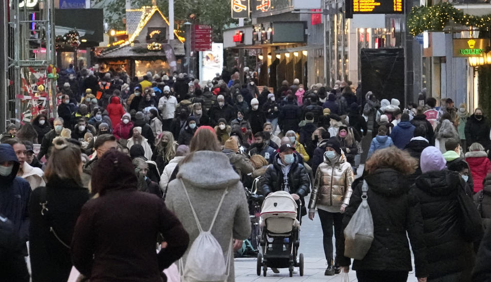 People wear mandatory face masks in a shopping street in Dortmund, Germany, on Dec. 1, 2021. Source: AP Photo/Martin Meissner