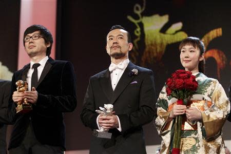 Diao Yinan director of "Bai Ri Yan Huo" (Black Coal, Thin Ice) poses with his Golden Bear for Best Film next to actor Liao Fan (C) who poses with his Silver Bear for Best Actor, and actress Haru Kuroki (R) who holds her Silver Bear for Best Actress, during the awards ceremony of the 64th Berlinale International Film Festival in Berlin February 15, 2014. REUTERS/Tobias Schwarz
