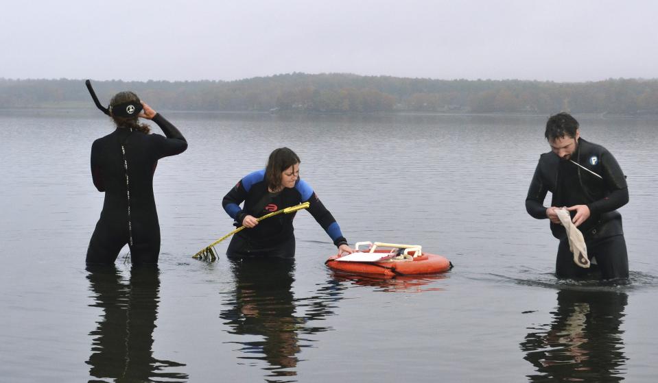 In this Oct. 29, 2019 photo, from left, University of New Hampshire's Lara Martin,Nikki Sarrette and Nick Anderson monitor the health of eel grass in the Great Bay in Durham, N.H. Their sampling work is part of a global effort to monitor the health of seagrass, which is critical for water quality in the bay and serves as food source and shelter for fish, crustaceans and other marine animals. (AP Photo/Michael Casey)