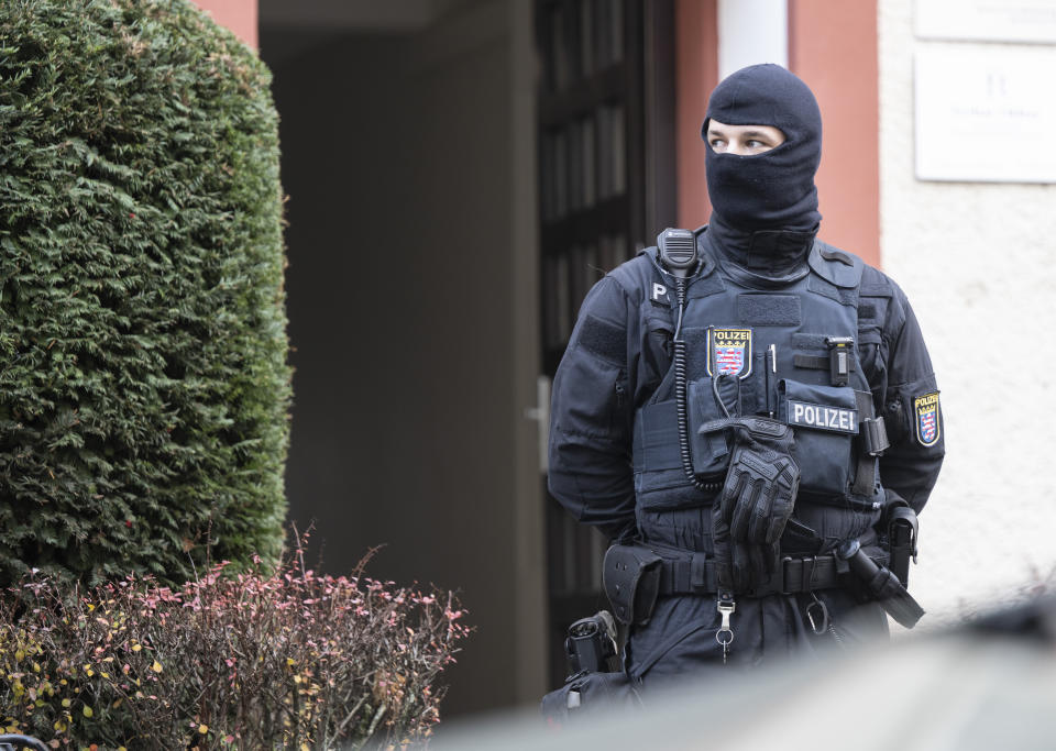 Police officers stand by a searched property in Frankfurt during a raid against so-called 'Reich citizens' in Frankfurt, Germany, Wednesday, Dec. 7, 2022. Thousands of police carried out a series of raids across much of Germany on Wednesday against suspected far-right extremists who allegedly sought to overthrow the state by force. Federal prosecutors said some 3,000 officers conducted searches at 130 sites in 11 of Germany's 16 states against adherents of the so-called Reich Citizens movement. Some members of the grouping reject Germany's postwar constitution and have called for the overthrow of the government. (Boris Roessler/dpa via AP)