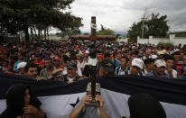 <p>A Honduran migrant holds up a replica of the Black Christ of Esquipulas as Guatemalan police temporarily block the road after the caravan crossed the Honduras-Guatemala border without incident, in Esquipulas, Guatemala, Monday, Oct. 15, 2018. (Photo: Moises Castillo/AP) </p>