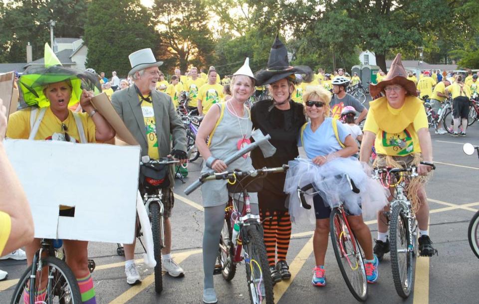 Bicyclists pose for photos in costumes based on characters from “The Wizard of Oz.”