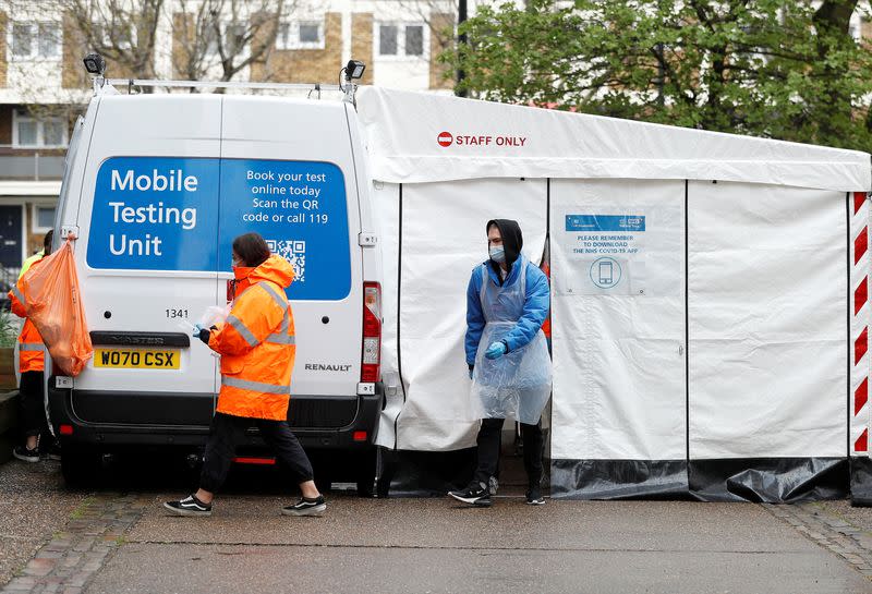 NHS workers are seen next to a coronavirus disease (COVID-19) mobile testing unit in Tower Hamlets, London