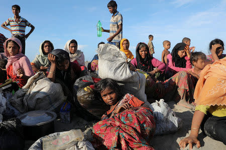 Exhausted Rohingya refugees rest after arriving by a wooden boat from Myanmar to the shore of Shah Porir Dwip, in Teknaf, near Cox's Bazar in Bangladesh, October 1, 2017. REUTERS/Mohammad Ponir Hossain