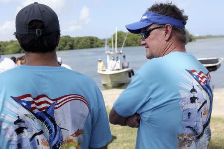 U.S. artist and conservationist Guy Harvey (R) leads a group of volunteers along the San Juan estuary system for the second "mega cleanup" of garbage from the waterway, in San Juan, in this October 26, 2013 file picture. REUTERS/Alvin Baez/Files