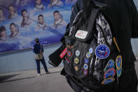 A staff member carries a bag with the past Shenzhou missions badges and pins as he arrives to meet the Chinese astronauts for the upcoming Shenzhou-17 mission at the Jiuquan Satellite Launch Center in northwest China, Wednesday, Oct. 25, 2023. (AP Photo/Andy Wong)