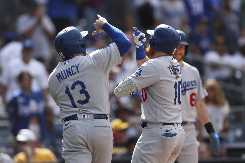 Los Angeles Dodgers' Justin Turner, front right, celebrates with Max Muncy (13) after hitting a grand slam against the San Diego Padres in the seventh inning of a baseball game Sunday, Sept. 11, 2022, in San Diego. (AP Photo/Derrick Tuskan)