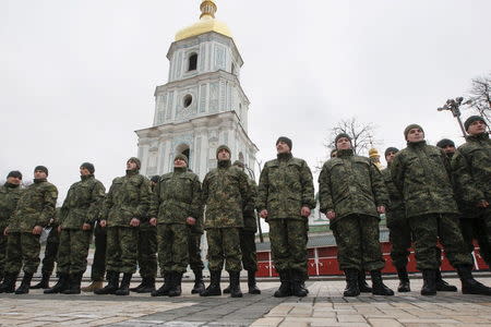 Members of the newly created Ukrainian interior ministry battalion "Saint Maria" attend a ceremony before heading to a military training, in front of St. Sophia Cathedral, in Kiev, Ukraine, February 3, 2015. REUTERS/Valentyn Ogirenko