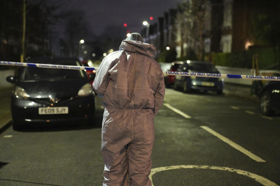 Police inspect the scene of an incident near Clapham Common, south London, after a suspected corrosive substance was thrown at a woman and her two young children Wednesday Jan. 31, 2024. British police said Wednesday they are hunting for a suspect after several people were injured with a corrosive substance in London.(James Weech/PA via AP)