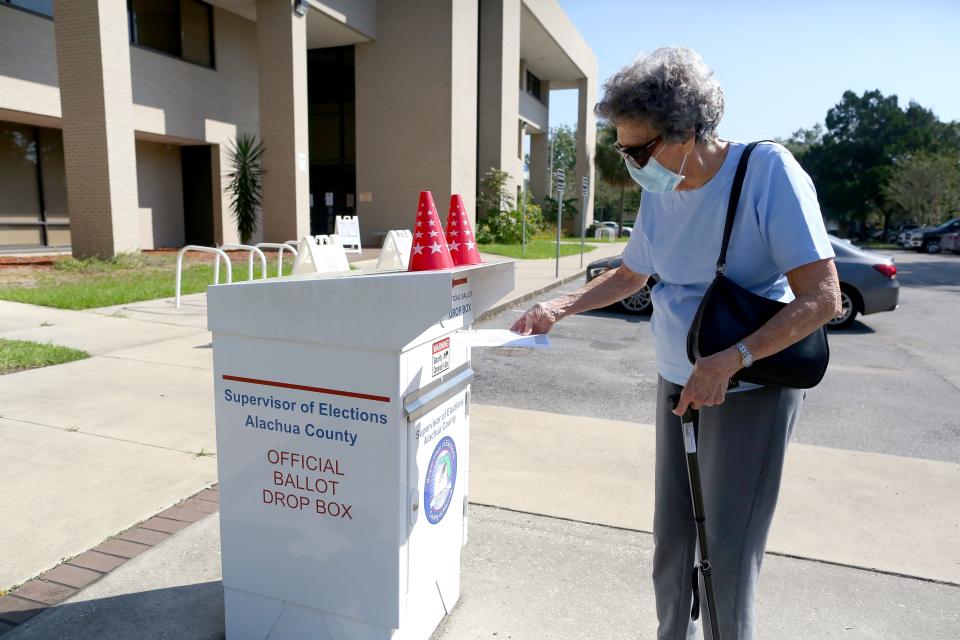 A voter puts her mail-in ballot in the drop box — now called a Secure Ballot Intake Station — at the Alachua County Supervisor of Elections Office in Gainesville in 2020.