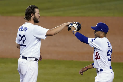 Los Angeles Dodgers starting pitcher Clayton Kershaw, left, high-fives Mookie Betts after the team's 3-0 win over the Milwaukee Brewers in Game 2 of a National League wild-card baseball series Thursday, Oct. 1, 2020, in Los Angeles. (AP Photo/Ashley Landis)