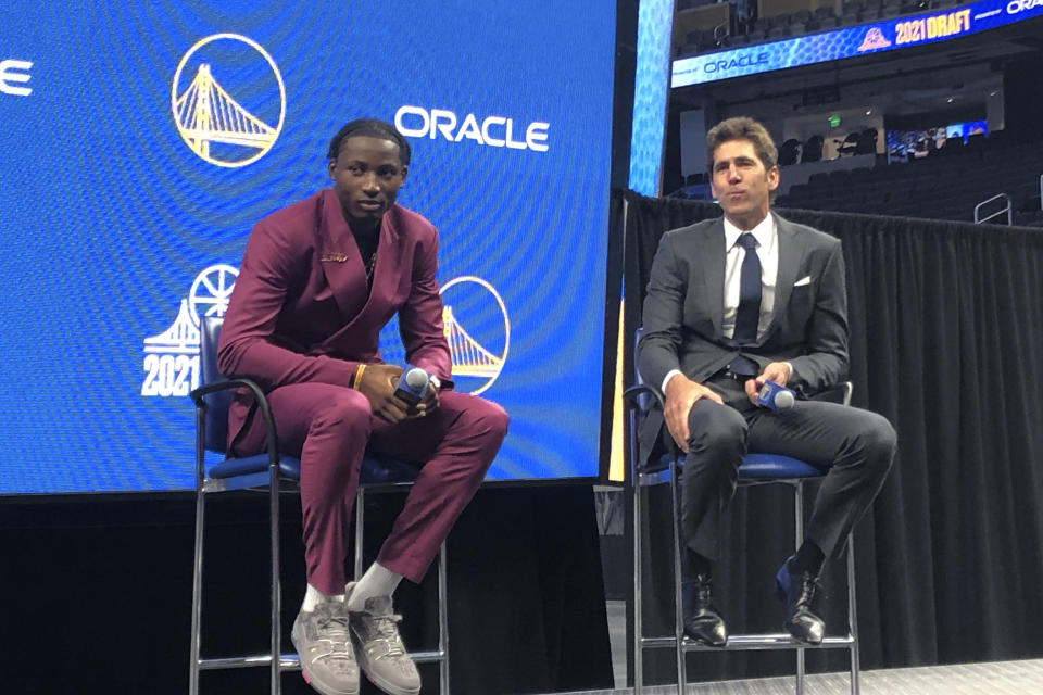 Golden State Warriors draft pick Jonathan Kuminga, left, and general manager Bob Myers answers questions during a news conference at Chase Center in San Francisco on Friday, July 30, 2021. (AP Photo/Janie McCauley)