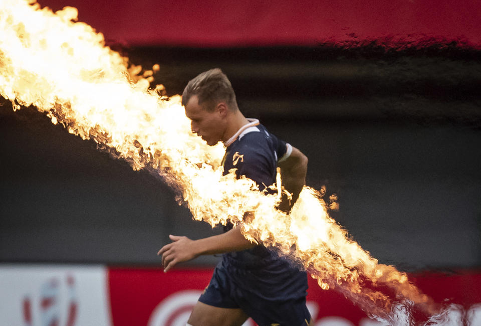 Spain's Enrique Bolinches runs past pyrotechnics before an HSBC Canada Sevens rugby match against Canada in Vancouver, British Columbia, Sunday, Sept. 19, 2021. (Darryl Dyck/The Canadian Press via AP)