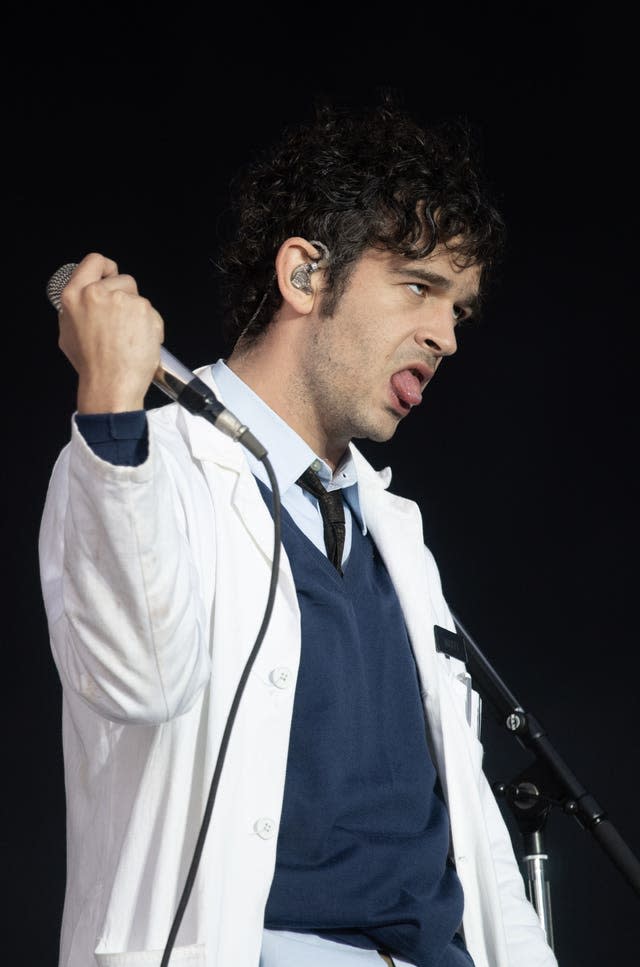 Matty Healy performing in a white coat