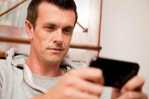 Man using a smart phone at home