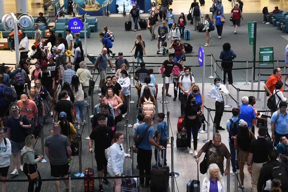 Travelers make their way through a TSA screening line at Orlando International Airport ahead of the July 4 holiday