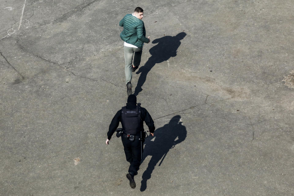 A police officer runs to detain a demonstrator preventing an opposition action to protest the official presidential election results in Minsk, Belarus, Saturday, March 27, 2021. Belarusian opposition has urged people to protest against repressions in the country and Lukashenko's regime. (AP Photo)