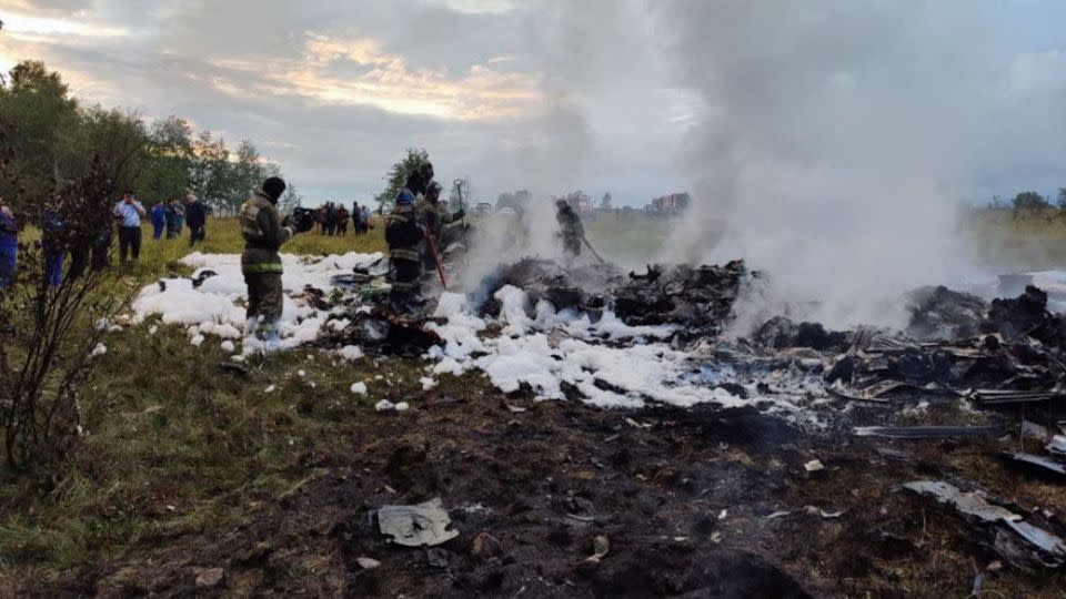 Firefighters work amid the wreckage on August 23 following the crash of Prigozhin's private jet. - Investigative Committee of Russia/Reuters