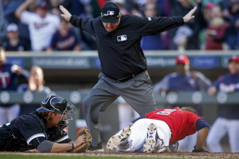 Brian Dozier looks at the ump after sliding into home to complete an inside-the-park home run (AP Photo/Bruce Kluckhohn).