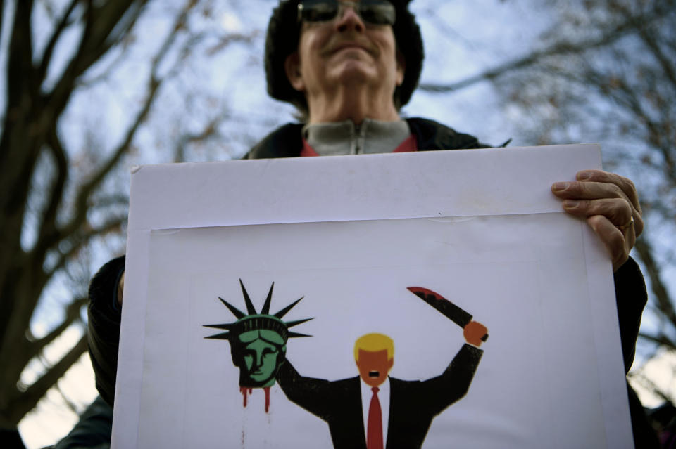 An activist holds a sign to protest US President Donald Trump during Presidents' Day in Lafayette Square near the White House on Feb. 18, 2019 in Washington, D.C. (Photo: Brendan Smialowski/AFP/Getty Images)