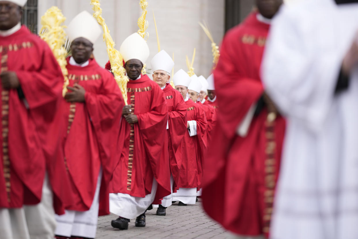 Cardinals arrive in a procession at the start of the Palm Sunday's mass celebrated by Pope Francis in St. Peter's Square at The Vatican Sunday, April 2, 2023 a day after being discharged from the Agostino Gemelli University Hospital in Rome, where he has been treated for bronchitis, The Vatican said. The Roman Catholic Church enters Holy Week, retracing the story of the crucifixion of Jesus and his resurrection three days later on Easter Sunday. (AP Photo/Andrew Medichini)