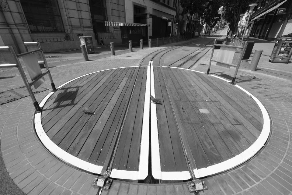 A pair of pigeons make their way across the empty Powell Street cable car turntable in San Francisco on April 17, 2020. Normally, the months leading into summer bring bustling crowds to the city's famous landmarks, but this year, because of the coronavirus threat they sit empty and quiet. Some parts are like eerie ghost towns or stark scenes from a science fiction movie. (AP Photo/Eric Risberg)