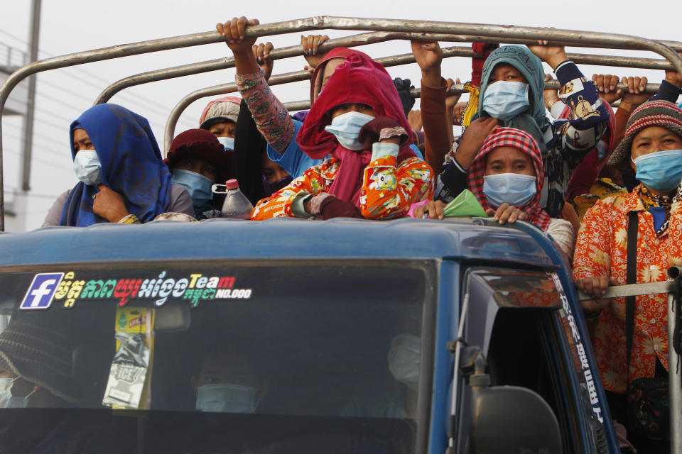 Garment workers stand on a truck as they head to work outside Phnom Penh, Cambodia, Thursday, May 6, 2021. Cambodia on Thursday ended a lockdown in the capital region. (AP Photo/Heng Sinith)