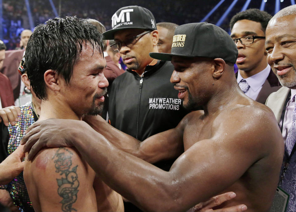 FILE - In this May 2, 2015, file photo, Manny Pacquiao, left, from the Philippines, and Floyd Mayweather Jr., embrace in the ring at the finish of their welterweight title fight in Las Vegas.  Mayweather Jr. says he's coming out of retirement again to fight Pacquiao for a second time in December. Mayweather posted a video on Instagram early Saturday, ept. 15, 2018, that showed Pacquiao and him together, reportedly in Japan, jawing at each other over a possible second fight. Representatives for the two fighters could not immediately be reached for comment.   (AP Photo/Isaac Brekken, File)