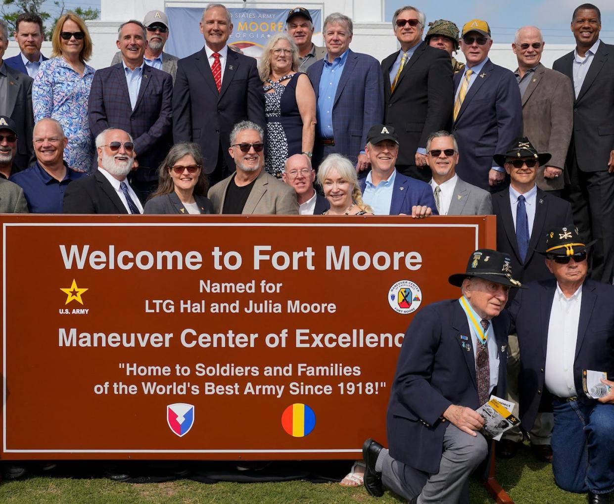 People pose next to a newly unveiled Fort Moore sign on May 11, 2023. <a href="https://www.gettyimages.com/detail/news-photo/people-pose-for-photos-next-to-a-newly-unveiled-fort-moore-news-photo/1253877603?adppopup=true" rel="nofollow noopener" target="_blank" data-ylk="slk:Cheney Orr/AFP via Getty Images;elm:context_link;itc:0;sec:content-canvas" class="link ">Cheney Orr/AFP via Getty Images</a>