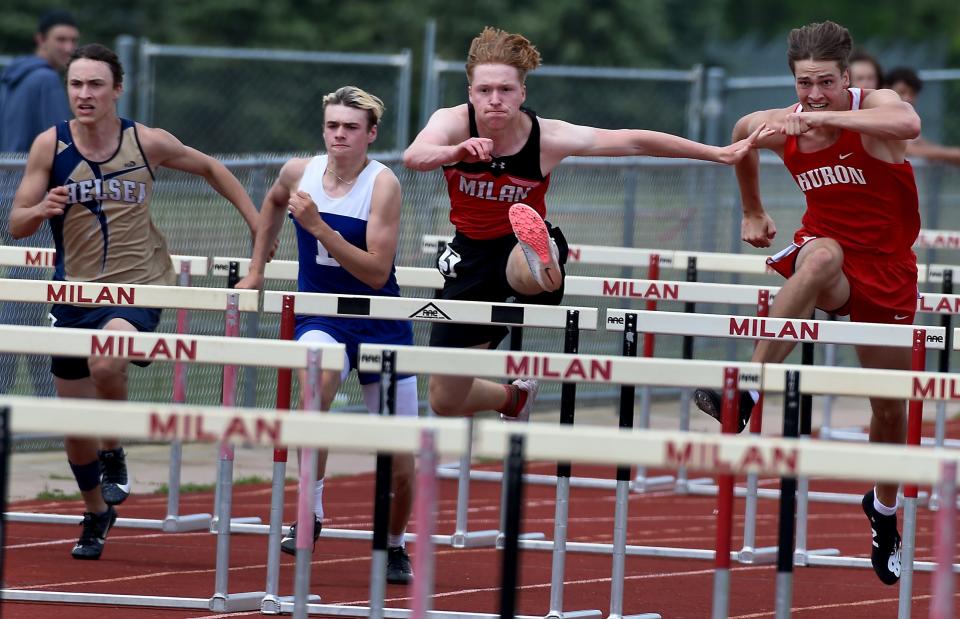 Zach Spradlin of Milan leaps over the hurdles to win the D2 Regional 110m high hurdles at Milan Friday, May 20, 2022. Right is Miles Fichtner of Huron who placed second, behind is Johnny Swisher of Dundee who placed fourth and Andrew Hilbert of Chelsea placed fifth.