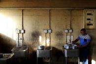 Zakhele Ntsele cooks in a communal kitchen at Jeppestown men's hostel in Johannesburg May 19, 2015. REUTERS/Siphiwe Sibeko