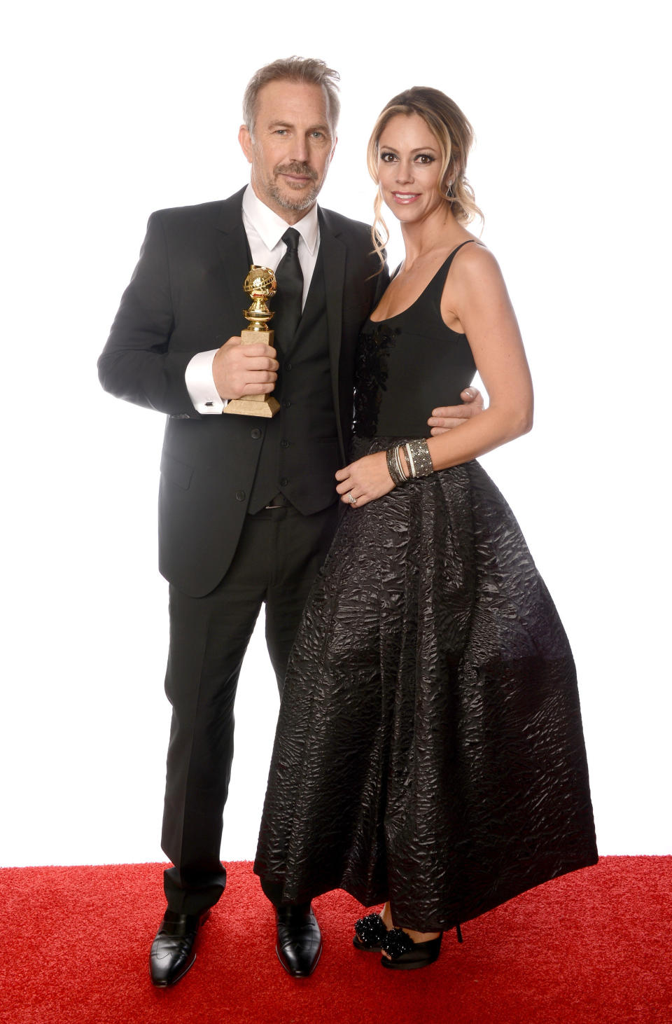 BEVERLY HILLS, CA - JANUARY 13:  Actor Kevin Costner, winner of Best Actor in a Mini-Series or a Motion Picture Made for Television for 'Hatfields & McCoys', and wife Christine Baumgartner pose for a portrait at the 70th Annual Golden Globe Awards held at The Beverly Hilton Hotel on January 13, 2013 in Beverly Hills, California.  (Photo by Dimitrios Kambouris/Getty Images)