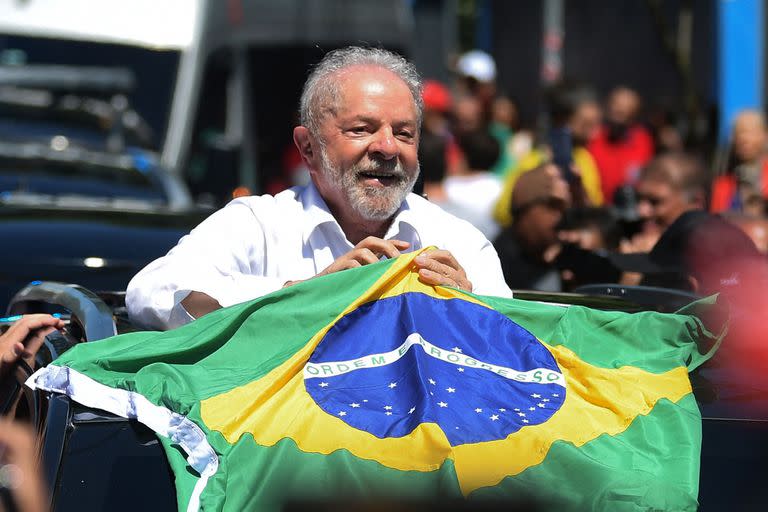 Lula da Silva, con una bandera brasileña en la mano, tras votar este mañana en San Pablo