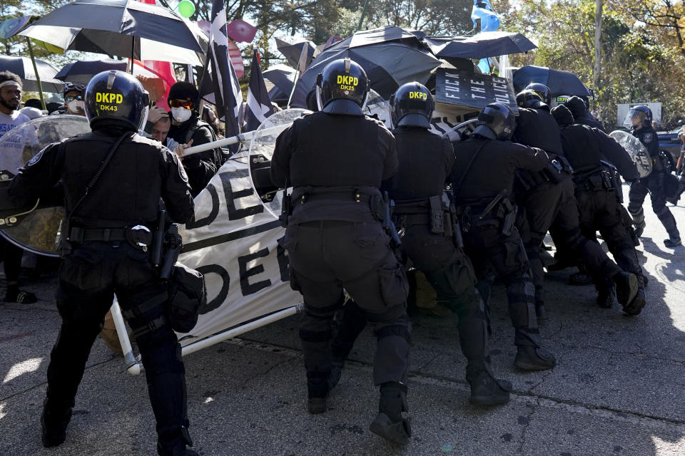 Protesters drive into a police line during a demonstration in opposition to a new police training center, Monday, Nov. 13, 2023, in Atlanta. (AP Photo/Mike Stewart)