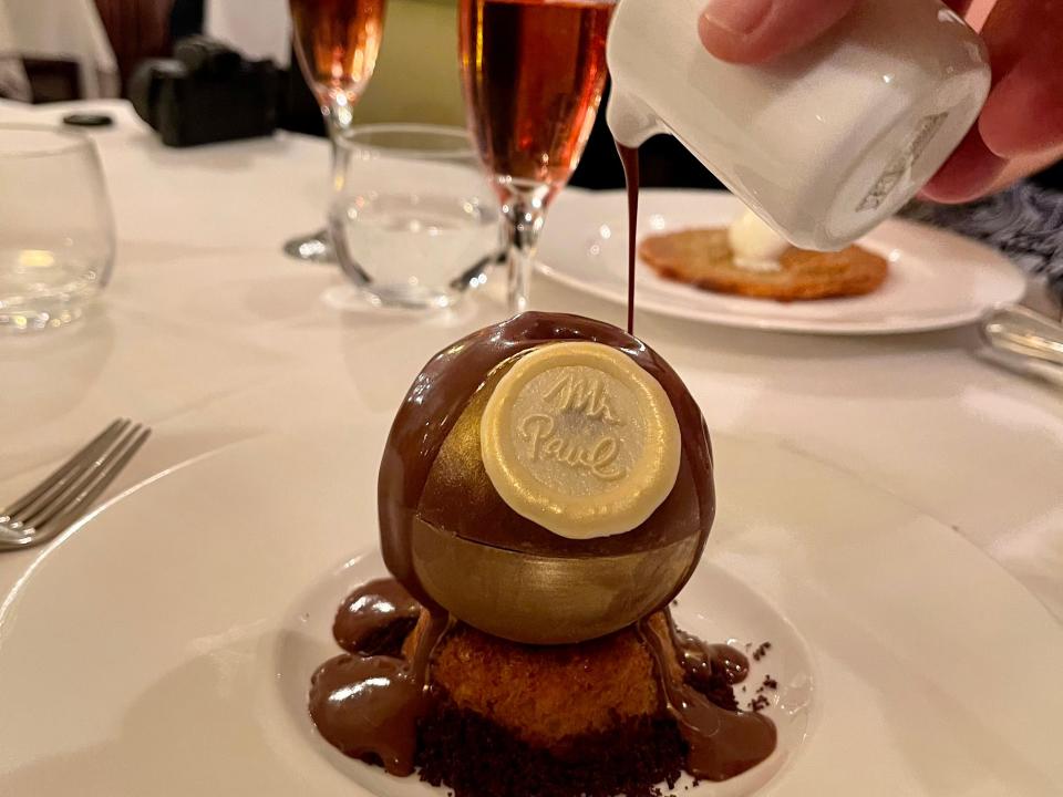 Chocolate dessert with sauce being poured on top.