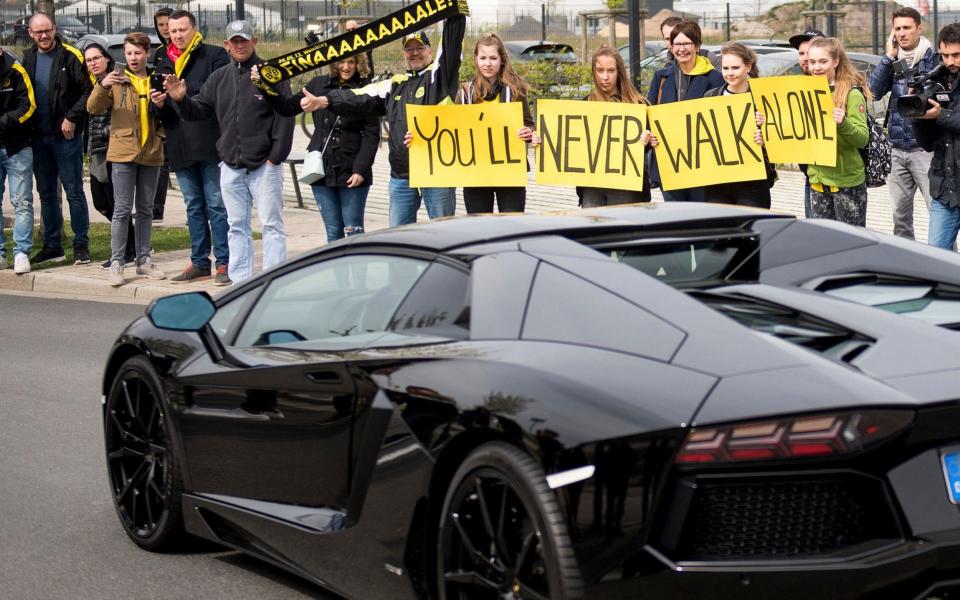 Fans show their support for Dortmund fans as player Pierre-Emerick Aubameyang leaves the training ground - Credit: Marius Becker/DPA/AP