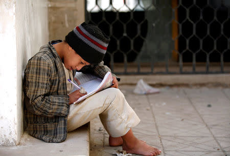 A boy studies in the yard of The al-Shawkani Foundation for Orphans Care in Sanaa, Yemen, January 9, 2017. REUTERS/Khaled Abdullah