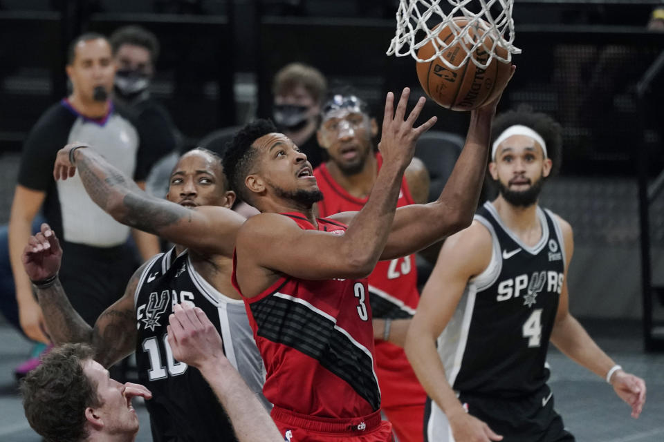 Portland Trail Blazers guard CJ McCollum (3) drives to the basket past San Antonio Spurs forward DeMar DeRozan (10) during the second half of an NBA basketball game in San Antonio, Friday, April 16, 2021. (AP Photo/Eric Gay)