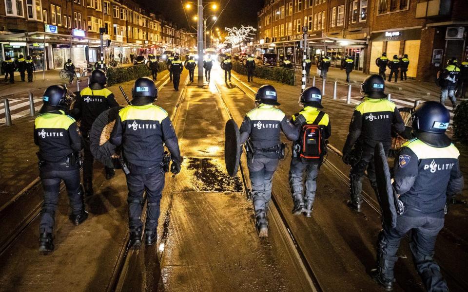 Dutch police officers patrol in the streets of Rotterdam, during the curfew time - AFP