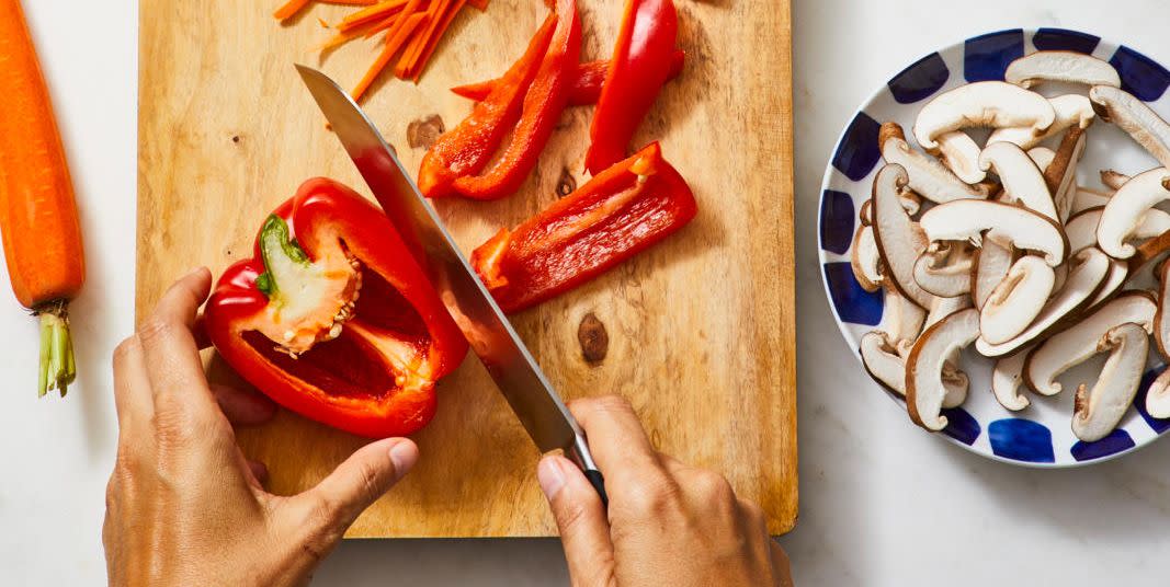 red bell pepper being cut up on a wooden board