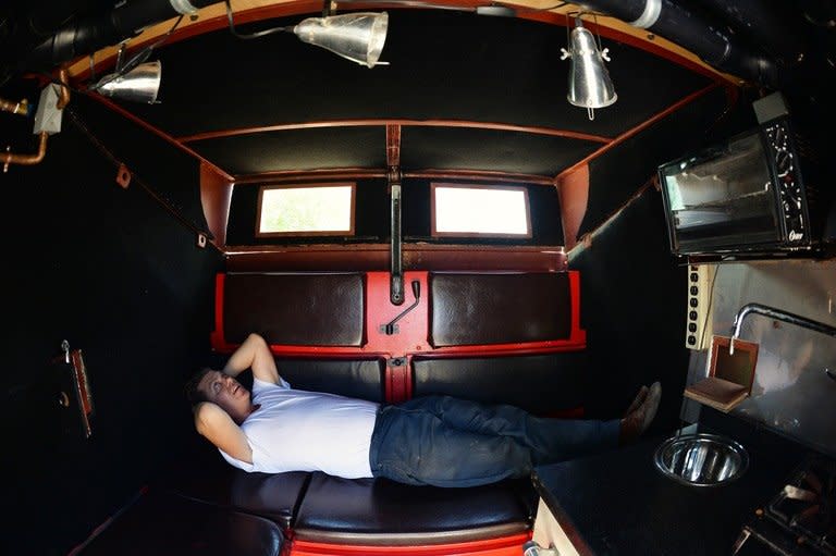 Greg Kloehn lying inside the home he made from a dumpster, pictured August 15, 2013 in New York. He bought the dumpster for $1,000 and transformed into a mini home, complete with sink, propane stove and microwave oven