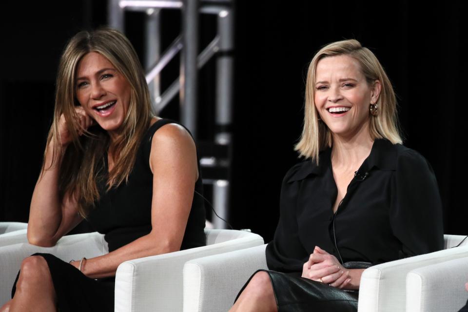 Reese Witherspoon and Jennifer Aniston onstage laughing