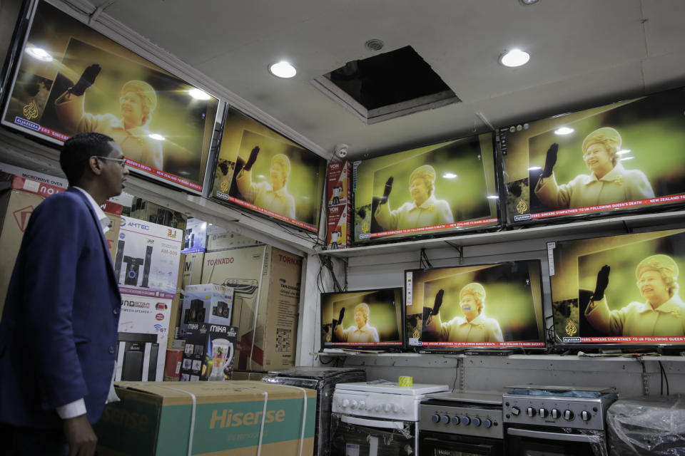 A salesman watches televisions showing coverage of the death of Queen Elizabeth II, at an electronics shop in downtown Nairobi, Kenya, Sept. 9, 2022. (AP Photo/Brian Inganga)