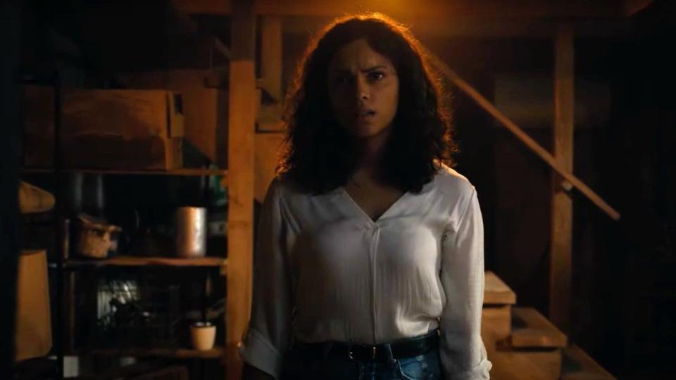 a woman stands looking at a spot in a creepy basement in a scene from barbarian, a good housekeeping pick for best halloween movies