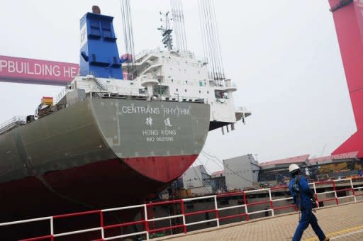 A worker walks past a freight boat under assembly at a port in Qingdao, east China's Shandong province on April 10, 2012. Further evidence of a slowdown in China's export-driven economy came with data showing output from its millions of factories and workshops rose at a much slower pace in the first three months of this year