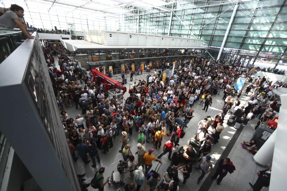 People wait inside the Munich Airport in Munich, Germany, Tuesday, Aug. 27, 2019. Munich Airport says it has closed some of its terminals because a person has likely entered the "clean area" through an emergency exit door. The international airport tweeted Tuesday morning that terminal 2 and areas B and C or terminal 1 had been closed for police operations.(AP Photo/Matthias Schrader)