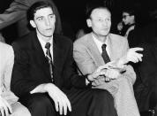 FILE - In this February 1953, file photo, Clarence "Bevo" Francis, left, reaches over to tug the sleeve of New York Knicks coach Joe Lapchick as they watch a basketball game between the Knicks and the Ft. Wayne Pistons at New York's 69th Regiment Armory in New York. Lapchick, was the first coach of the New York Knicks. Joe Lapchick's initial efforts to integrate what would become the NBA was thwarted in 1947 but he signed Nat “Sweetwater” Clifton in 1950. (AP Photo/File)